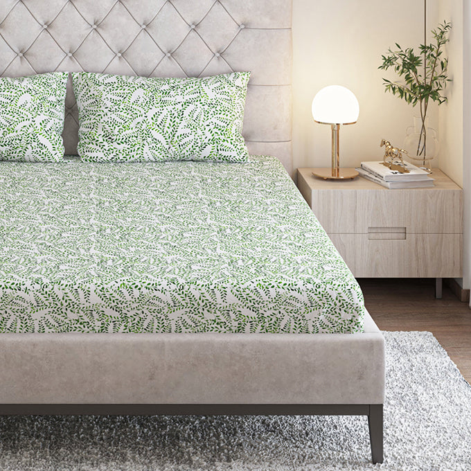 Green leaf-print Seevo cotton bedsheet set on a bed